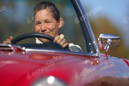 Preview: Horizontal Shot Of A Joyous Woman Driving A Red Convertible Car On A Sunny Day.