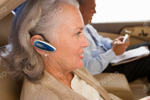 Preview: Profile Shot Of A Businessman And A Businesswoman In Back Seat Of A Car With Focus On The Woman