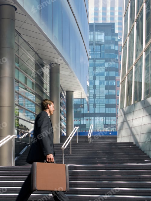 Preview: Businessman Holding A Briefcase Walking Towards The Stairs In The Routine Of Working With
