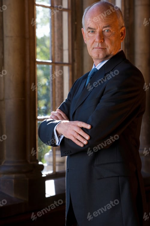 Preview: Portrait Of A Businessman With Arms Crossed Standing By The Window.
