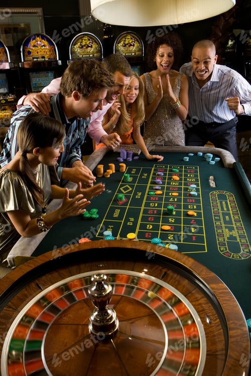 Preview: Group Of Men And Women Looking At The Roulette Table And Cheering While Playing A Game In The Casino