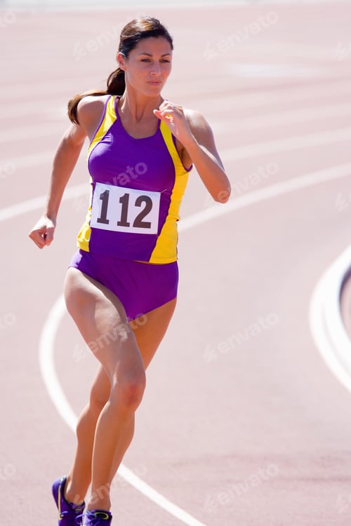 Preview: Young Female Athlete Running On Race Track At An Athletics Event On A Bright, Sunny Day