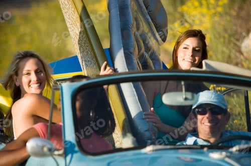 Preview: Horizontal Waist Up Shot Of A Group Of Smiling Teenagers With Surfboards In A Convertible Car On A