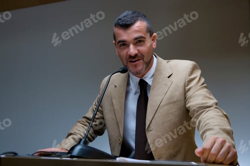 Preview: Horizontal Waist Up Portrait Of Businessman Behind With Hands On The Podium Delivering A Speech And