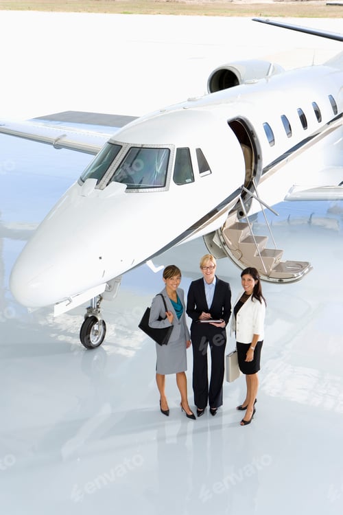 Preview: Elevated View Of Three Businesswomen Posing In Front Of A Private Jet On The Runway.