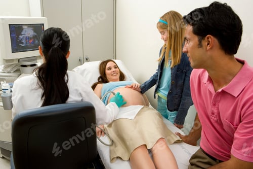 Preview: Pregnant Woman Lying On The Bed And Getting A Sonography While Her Husband And Daughter Are