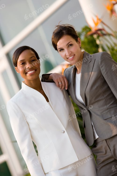 Preview: Vertical Three Quarter Length Portrait Of Two Businesswoman Smiling At The Camera.