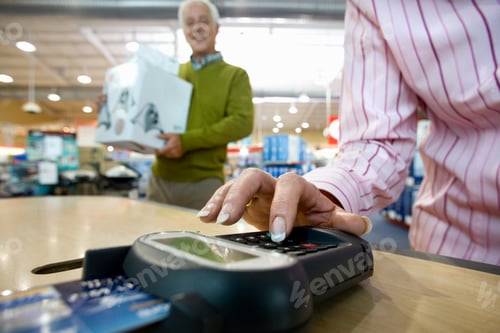 Preview: Close Up Shot Of A Senior Woman Typing Her Credit Card Pin While Paying For The Purchase Of