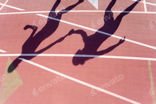 Preview: Shadow Of A Young Female Athlete Handing Over The Relay Baton To Her Teammate At An Athletics