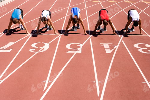 Preview: Male Sprinters Waiting For The Start Of A Sprint Race On Their Starting Blocks Behind Lane Markings