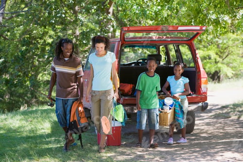 Preview: Horizontal Shot Of A Family Unloading Stuff From A Parked Suv On A Camping Trip With Children