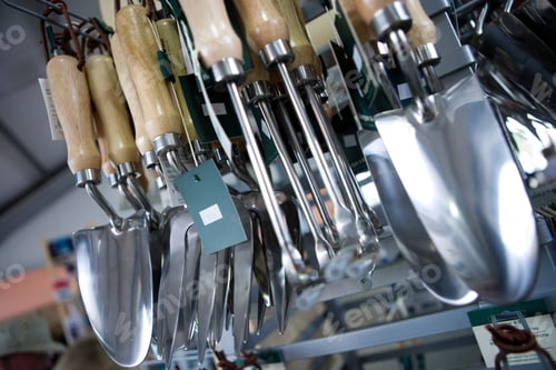 Preview: Tilted Close-Up Shot Of Gardening Tools Hung In Racks Inside A Shop.