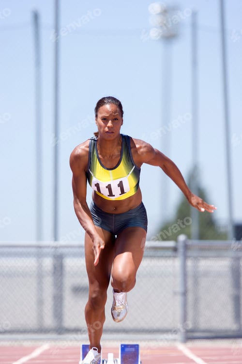 Preview: Middle-Aged Female Athlete Setting Off From The Starting Blocks During A Sprint Race At An