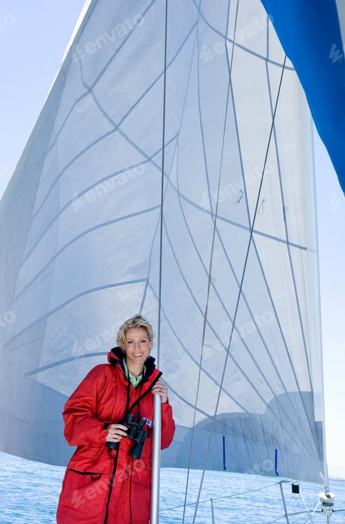 Preview: Portrait Of A Woman In A Red Jacket With Binoculars Standing On The Deck Of A Sailing Boat Below