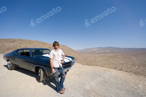 Preview: Horizontal Shot Of A Young Man In Sunglasses With Water Bottle Leaning On The Car In The Desert.