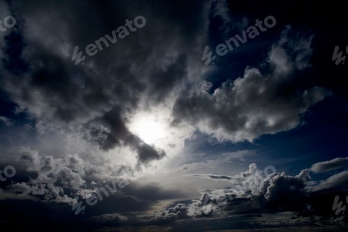 Preview: Natural Blue Sky With Fluffy Clouds Hiding The Sun Behind.