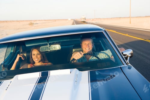 Preview: Horizontal Shot Of A Young Couple In A Car Driving On A Desert Road With A Smile.
