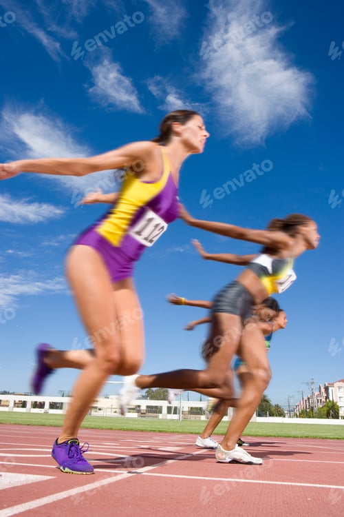 Preview: Female Athletes Clearing The Finish Line On A Bright, Sunny Day At An Athletics Event At The Race