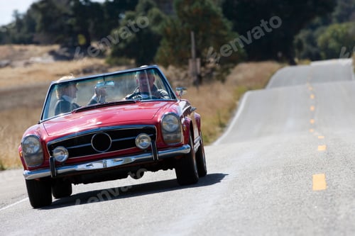 Preview: Horizontal Front View Of A Joyous Senior Couple On A Road Trip In A Red Convertible With The Woman
