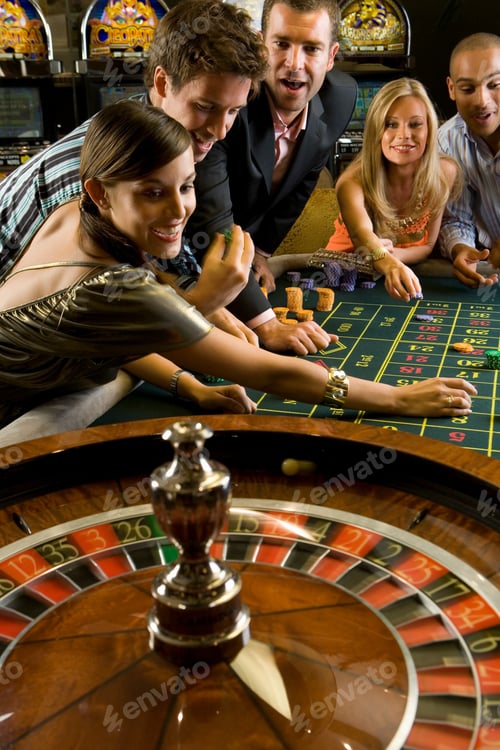 Preview: Vertical Shot Of A Group Of Men And Women Enjoying Their Time And Gambling At The Roulette Table In