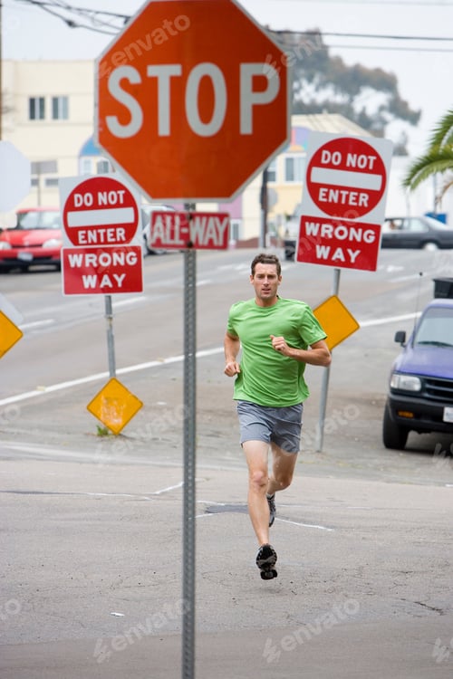 Preview: Full Length Portrait Of A Man Running Towards The 'Stop' Sign On A Street.