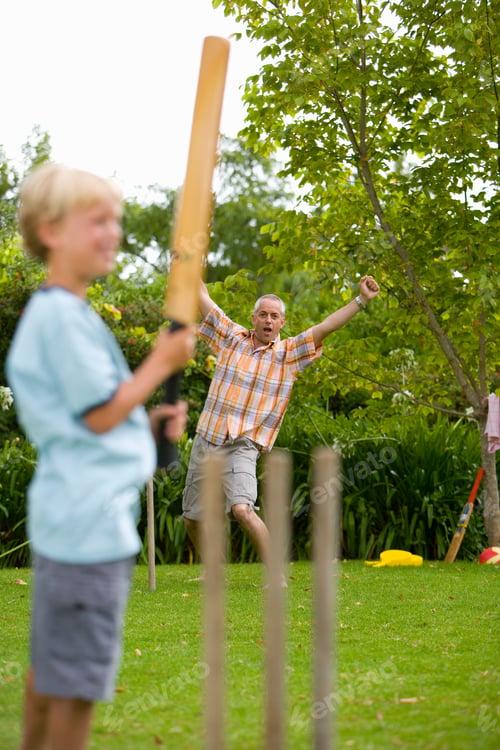 Preview: Young Boy Playing Cricket With His Father As He Is Cheering On A Bright, Sunny Day Out In The Park