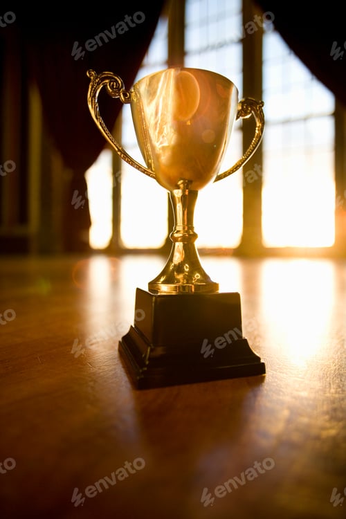 Preview: Championship Golden Trophy Placed On Wooden Floor With The Background Of Sunlight Coming Through