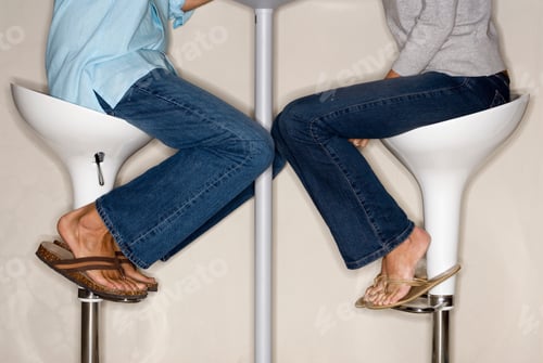 Preview: Horizontal Profile Shot Of Lower Section Of A Couple Sitting On Stools Face To Face.