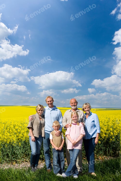 Preview: Vertical Portrait Of A Multi-Generational Family Standing In Field Smile At The Camera On A Sunny