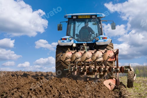 Preview: Rear View Of A Tractor Ploughing The Field On A Sunny Day.