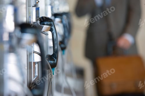 Preview: Selective Focus On A Receiver In A Telephone Bank With Mid Section Of A Businessman In The