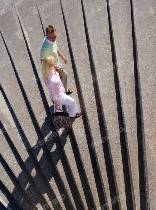 Preview: Woman Carrying A Shopping Bag Is Walking Up The Stairs With Her Husband After A Day Of Shopping On
