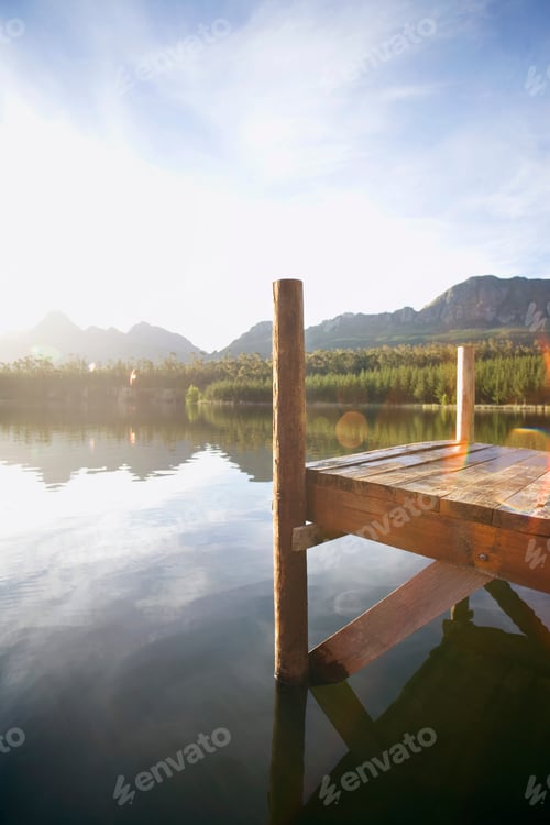 Preview: Vertical Side View Of A Jetty Besides A Tranquil Lake In Bright Sunlight.
