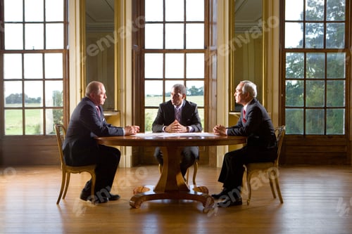 Preview: Three Senior Businessmen Sitting At The Table In Their Office And Having A Serious Discussion About