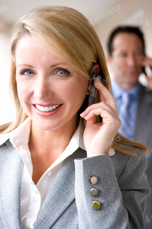 Preview: Vertical Close-Up Portrait Of A Businessman And Woman On The Move While Man Is Seen Using A Mobile