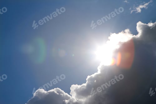 Preview: Sunbeams Peeking From Behind A Big Cloud Against The Background Of A Blue Sky With A Lens Flare.