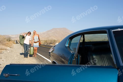 Preview: Horizontal Shot Of A Young Couple Hitchhiking And Walking Towards The Car On A Desert Road.
