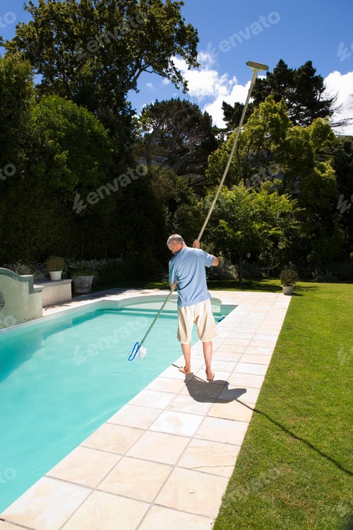 Preview: Rear View Of A Middle-Aged Man Cleaning The Swimming Pool With A Long Pole In His Hand On A Bright