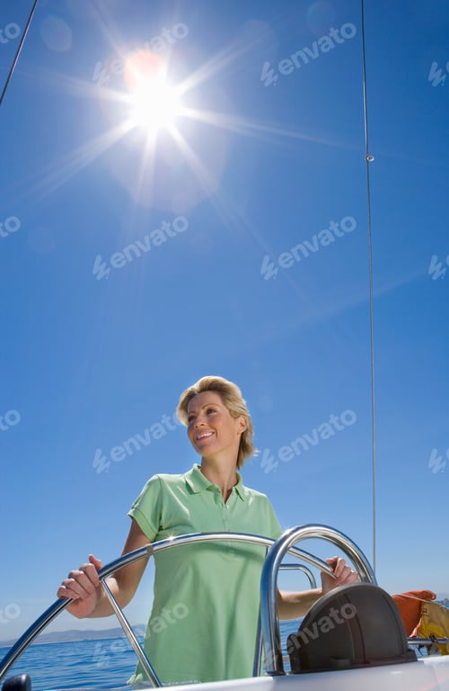 Preview: Vertical Shot F A Young Woman In Green Polo Shirt Standing At The Helm Of Sailing Boat Out At Sea
