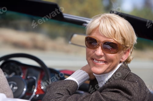 Preview: Tilted Head And Shoulder Rear View Of A Senior Woman Sitting In A Convertible Outdoors On A Sunny