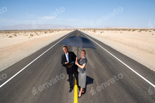 Preview: Horizontal Shot Of A Businessman And Woman On The Open Road In The Desert With A Laptop And An