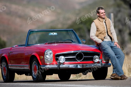 Preview: Horizontal Portrait Of A Young Man Sitting And Posing On Hood Of A Red Convertible On A Sunny Day