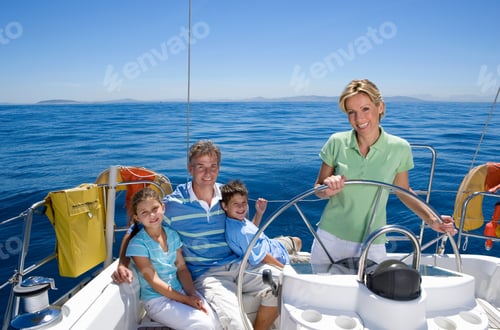 Preview: Horizontal Shot Of A Family Relaxing On The Deck Of A Sailing Boat Out At Sea With Mother Standing