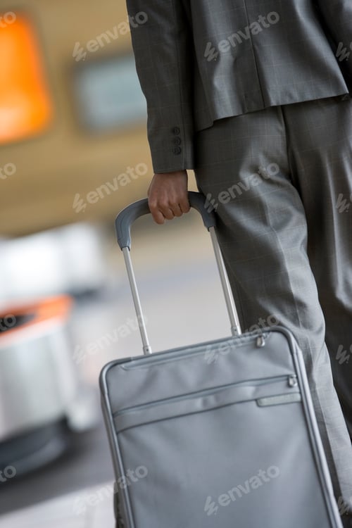 Preview: Vertical Rear View Of Mid Section Of A Businesswoman Walking With A Trolley Bag In An Airport.