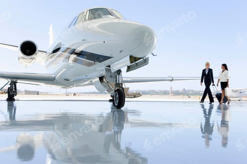Preview: Wide Shot Of Two Businesswomen Walking Towards Private Jet On The Runway.
