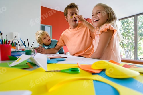 Preview: Little Girl Applying Paint To Her Father'S Face While They Are Painting With Her Little Brother In