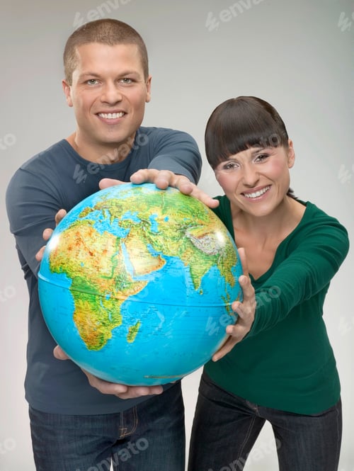 Preview: Young Couple In Their 20'S Is Holding Up A Globe In Their Outstretched Arms.