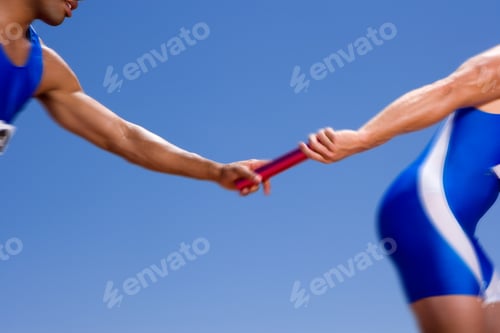 Preview: Close Up Of Hands Of A Young Male Athlete Receiving A Relay Baton From His Teammate On A Bright