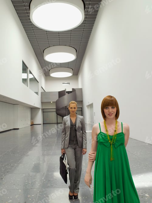 Preview: Two Businesswomen Walking Down The Corridor And Looking At The Camera.