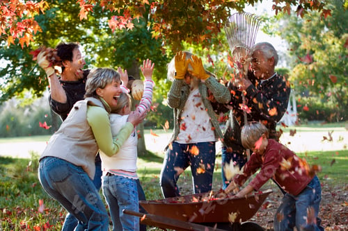 Preview: Horizontal Shot Of A Couple With Two Kids And Their Grandparents Playing With Autumn Leaves In A